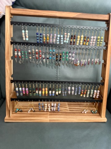 Earrings arranged on a wooden display rack